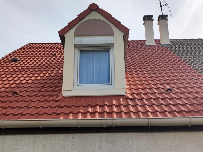 Toiture en tuiles rouge vif après traitement hydrofuge, gouttière zinc nette, en Île-de-France
